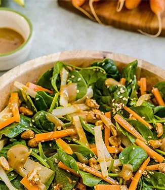 Spinatsalat med sprøde grøntsager og en dressing af sesam og jordnødder.